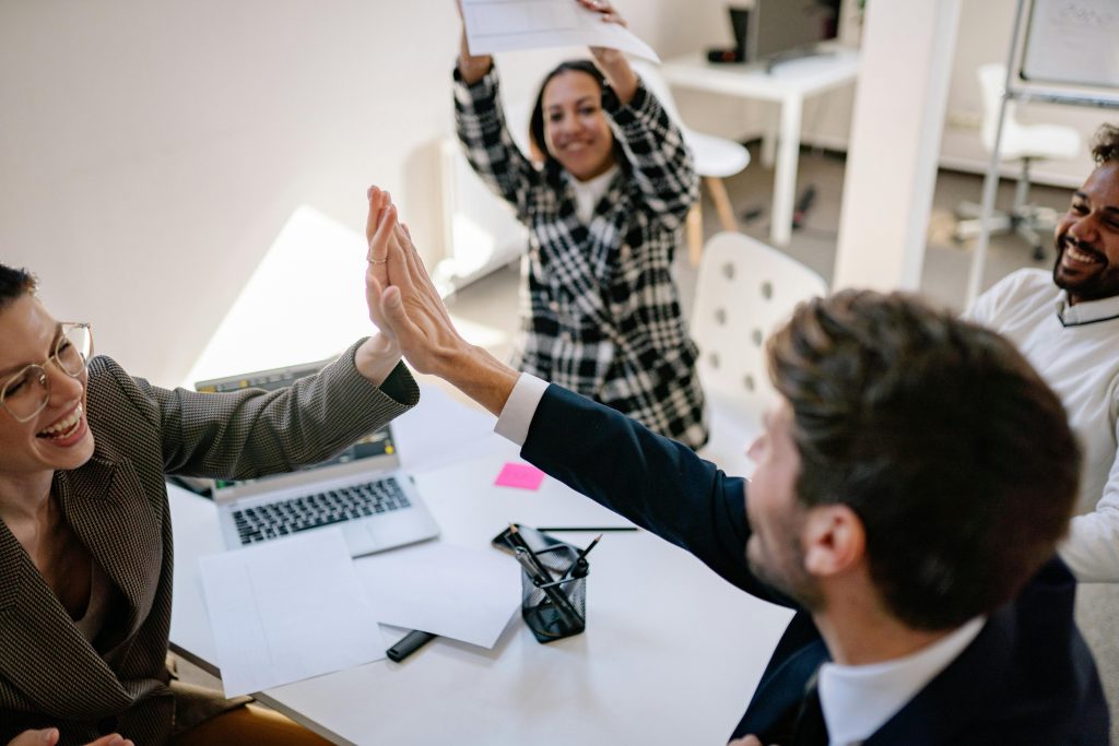 pexels-photo-7698820-7698820 Business team exchanging a joyful high five in a modern office environment.