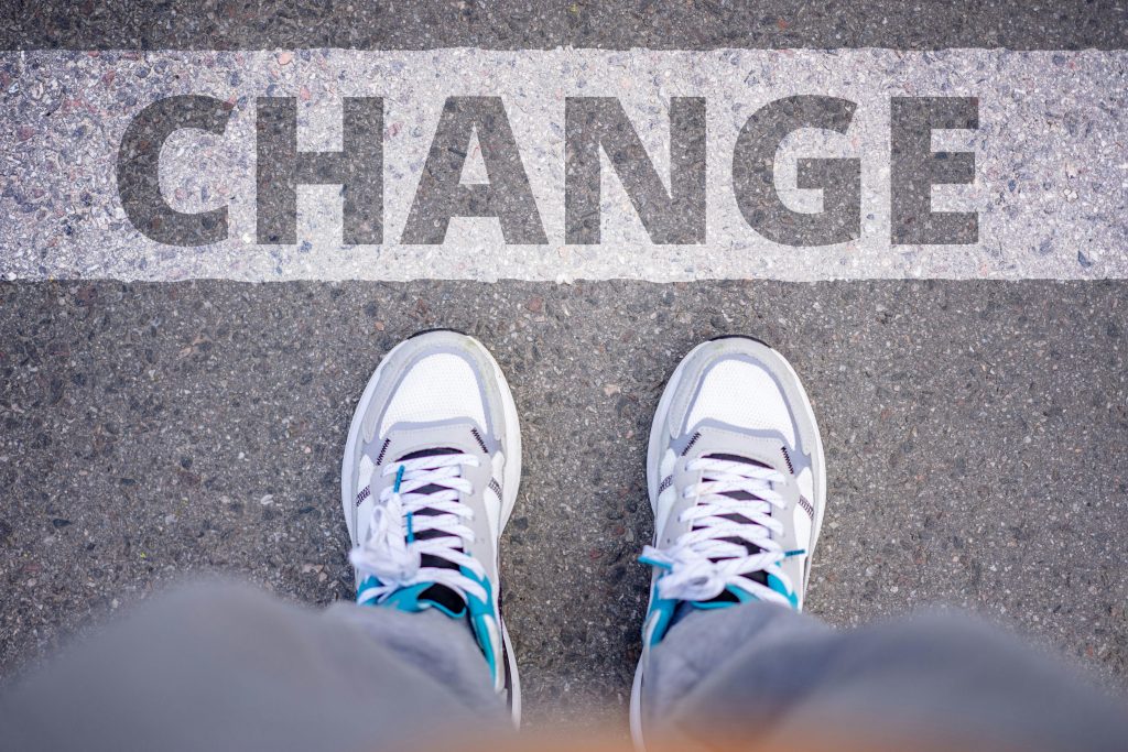 pexels-photo-9260443-9260443 Close-up of sneakers on street with 'Change' text, symbolizing transformation.